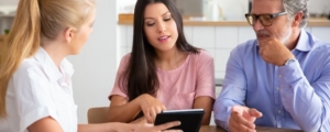 Famille réunie autour d'une table discutant de la transmission d'une entreprise avec un conseiller patrimonial